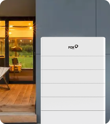 brand home battery unit installed on a modern home's exterior wall next to a wooden deck.