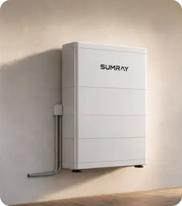 A white home battery storage unit installed on a modern home's exterior wall next to a lit patio
