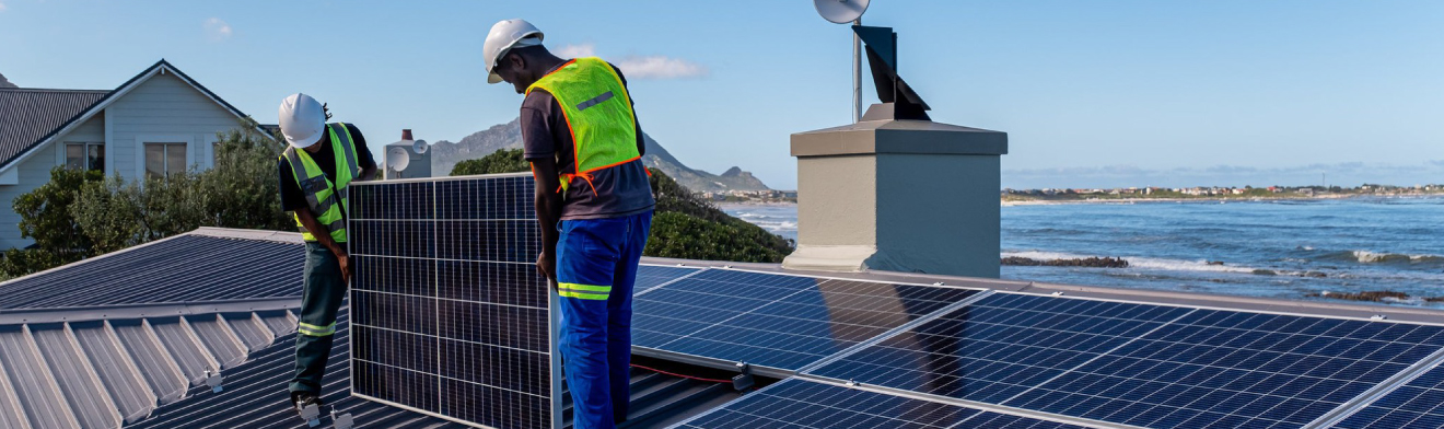 Two solar installers working on a rooftop