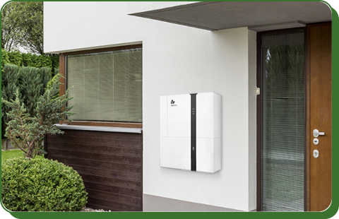 A modern white home battery unit, with a black panel mounted on the exterior wall of a house