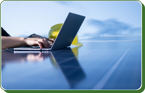 Solar technician using a laptop on a solar panel