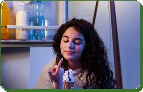 Person eating ice cream from a refrigerator during a power outage